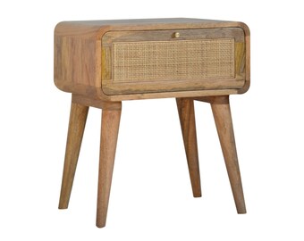 Puede incluir: Una mesita de noche de madera con un solo cajón que presenta un frente de ratán tejido. La mesa tiene una parte superior curva y cuatro patas cónicas.