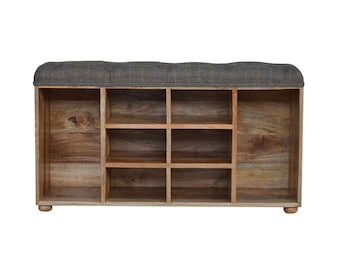 Puede incluir: Un banco de almacenamiento de zapatos de madera con una parte superior acolchada y ocho compartimentos. El banco está hecho de madera marrón claro y tiene una parte superior de tela a cuadros gris.