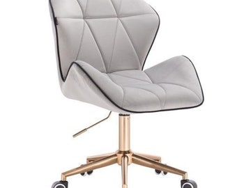 Puede incluir: Una silla de oficina de terciopelo gris con una base de metal dorado y cinco ruedas negras. La silla tiene un patrón geométrico en el respaldo y un ribete negro alrededor de los bordes.