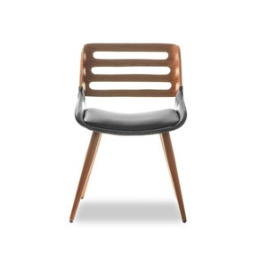 May include: A black leather dining chair with a wooden frame and four legs. The chair has a slatted back and a curved seat.
