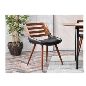 May include: A black leather dining chair with a wooden frame and a slatted back. The chair has four legs and is shown in a room with a wooden floor.