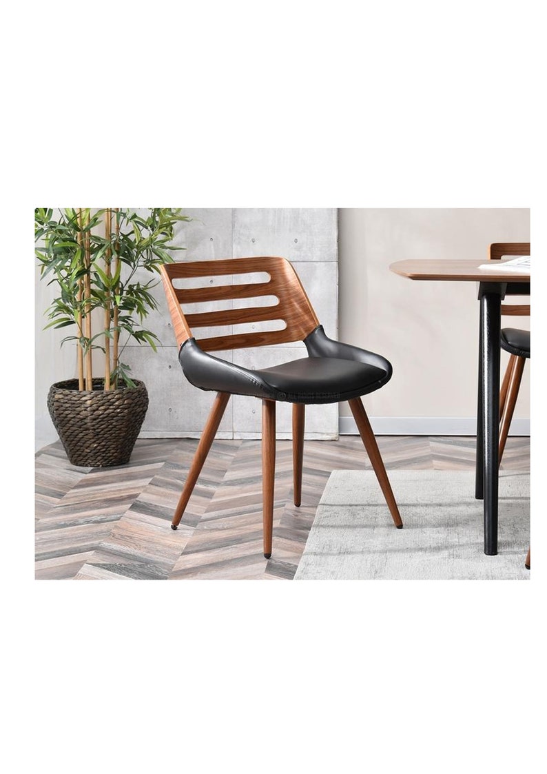 May include: A black leather dining chair with a wooden frame and a slatted back. The chair has four legs and is shown in a room with a wooden floor.