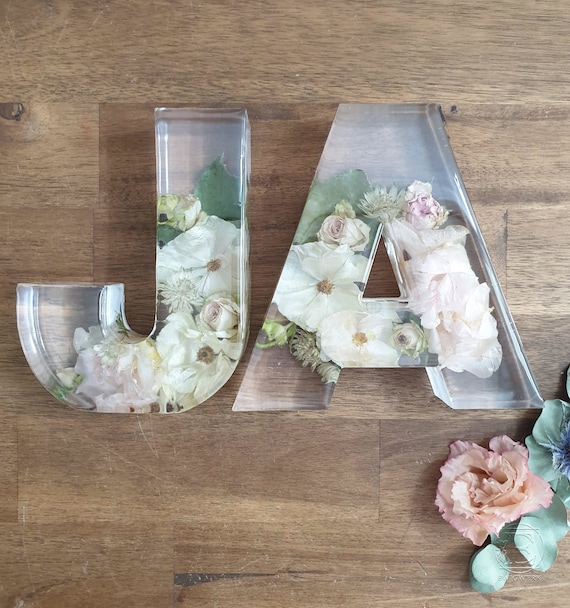 2 Stück Buchstaben aus Epoxidharz mit eingearbeiteten Blumen aus Deinem Brautstrauß.