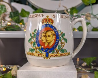 Taza antigua conmemorativa de la realeza, elaborada por Adams Pottery, que celebra la coronación del rey Jorge VI y la reina Isabel en 1937.