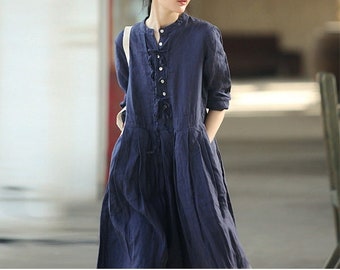 May include: A navy blue linen dress with a button-up front and a tie at the waist. The dress has a relaxed fit and a midi length.