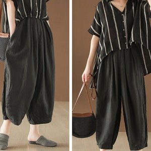 May include: A black and white striped linen shirt with a black linen pair of wide-leg pants. The shirt has a V-neck and a button-up front. The pants have a high waist and a relaxed fit.