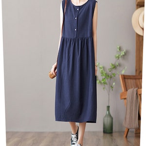 May include: A navy blue sleeveless midi dress with a button-up front and a slightly gathered skirt.