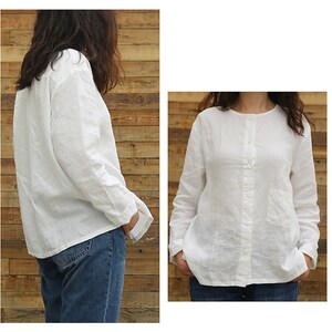 May include: A white linen shirt with long sleeves and a button-up front. The shirt has a small pocket on the left side.