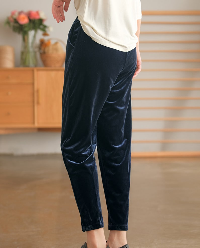 May include: Dark blue velvet pants with a relaxed fit and a slightly cropped length.