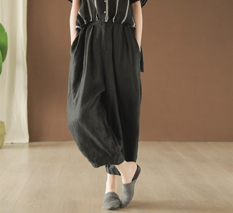 May include: Black linen pants with a wide leg and a loose fit. The pants have a high waist and are made of a soft, comfortable fabric.