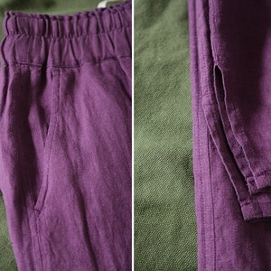 May include: A pair of purple linen pants with a drawstring waist and side pockets. The pants are folded and laid out on a green fabric background.