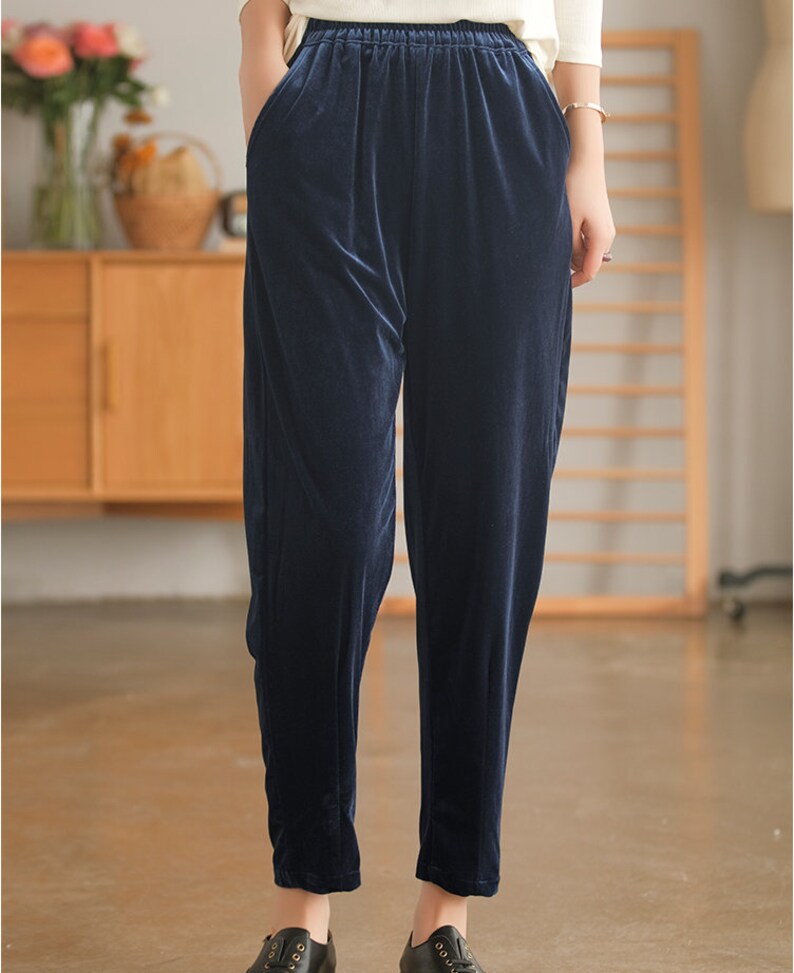 May include: Dark blue velvet pants with a wide waistband and a relaxed fit.