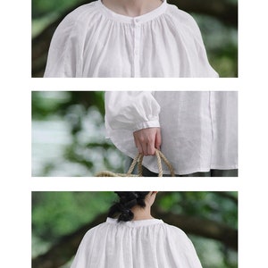 May include: A white linen blouse with a round neckline and long, gathered sleeves. The blouse has a button closure at the front.
