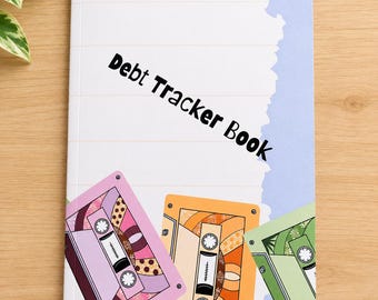 May include: A Debt Tracker Book with a white cover featuring faint horizontal lines, a light blue vertical border, and three colorful cassette tape illustrations in pink, orange, and green at the bottom. The text Debt Tracker Book is printed in black.