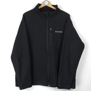 Puede incluir: Una chaqueta de forro polar negra con cremallera y el logotipo de Columbia en el pecho izquierdo.