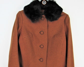May include: A brown and black checkered jacket with a black faux fur collar and cuffs. The jacket has a button closure.