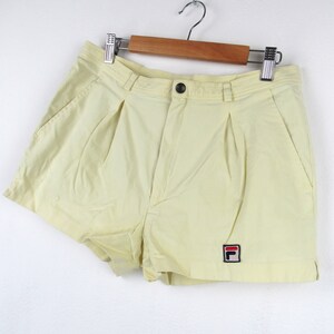 May include: Pale yellow athletic shorts with a small red, white, and blue "F" logo on the right leg.