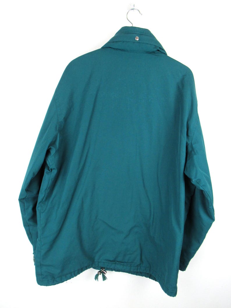 May include: A teal blue jacket with a zipper and a drawstring at the bottom.