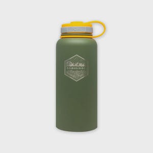 Puede incluir: Una botella de agua verde oliva con tapa y asa amarillas. La botella presenta un diseño de montaña y bosque dentro de un emblema hexagonal. La tapa tiene un anillo gris con las letras "PDW".