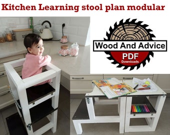 Puede incluir: Torre de aprendizaje de madera blanca con dos escalones y una parte superior negra. Un niño está sentado en el escalón superior. La torre está diseñada para ayudar a los niños a alcanzar las encimeras y participar en las actividades de la cocina. La imagen también muestra una mesa de madera blanca con una parte superior negra y dos escalones. La mesa está diseñada para que los niños la usen para actividades como dibujar o jugar. La imagen incluye el texto "Wood And Advice PDF Downloads".