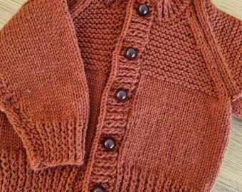 Age 3-6 months. Russet cardigan with cherry buttons. Handknitted super soft.