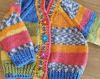 Age 3-6 months. Bright multicoloured v neck cardigan with daisy buttons. Handknitted super soft.