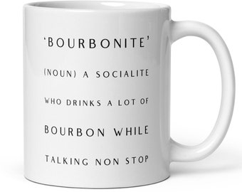 Könnte beinhalten: Eine weiße Keramik-Kaffeetasse mit schwarzem Text, der 'BOURBONITE' (NOUN) A SOCIALITE WHO DRINKS A LOT OF BOURBON WHILE TALKING NON STOP lautet.