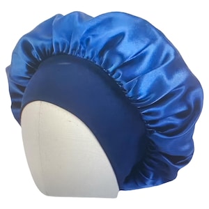 May include: A royal blue satin bonnet with a dark blue band. The bonnet is designed to protect hair and maintain hairstyles. The satin material provides a smooth surface to reduce friction and prevent breakage. The bonnet is shown on a white mannequin head.