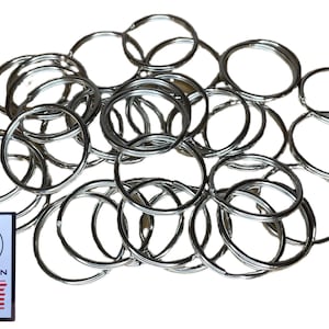 May include: A pile of silver key rings. There are approximately 30 key rings in the image.