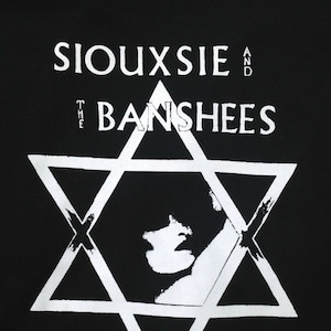 Op de afbeelding: Zwart-wit grafisch ontwerp met een zespuntige ster met een gestileerd gezicht erin. De tekst "Siouxsie and the Banshees" staat boven de ster.