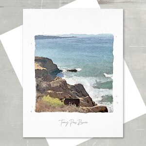 May include: A watercolor print of a coastal scene featuring a rocky cliffside and ocean waves. The print is on a white card with the text "Torrey Pines Reserve" in a handwritten font. The color palette includes shades of blue, brown, and green.