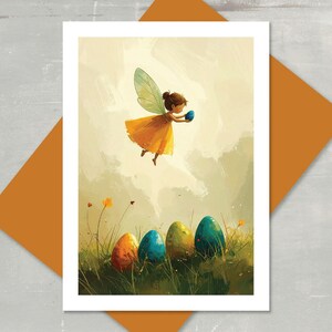 May include: An Easter-themed art print featuring a fairy in a yellow dress with green wings, holding a blue egg. Colorful Easter eggs are in the grass below. The print is on a white card with an orange envelope.