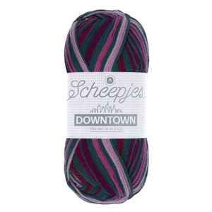 May include: A skein of Scheepjes Downtown yarn in the colourway "Downtown" with a multi-coloured striped pattern of pink, green, and purple.