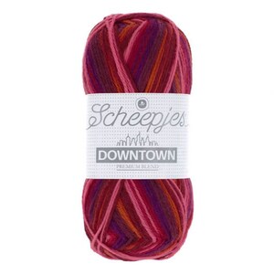 May include: A skein of Scheepjes Downtown yarn in the colourway "Downtown" with a multi-coloured striped pattern of pink, orange, and purple.