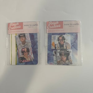 May include: Two sticker packs with a blue and white watercolour background. Each pack has a pink header with the text "Reya Creates" and "wave to earth happy mail" and "hand-made sticker pack". The sticker packs feature photos of a young man with different hairstyles and accessories. The stickers have text that says "DONGKYU" and "STAN WAVE 2 EARTH".