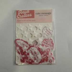 May include: A pack of pink and white hand-made stickers with cute messages such as "Be your own cupcake" and "Cute tel te!"  Reya Creates hand-made sticker pack.  cute message pink deco stickers.
