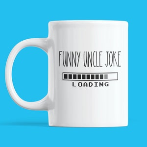 May include: White ceramic mug with the text "FUNNY UNCLE JOKE" and a loading bar graphic. The mug has a curved handle and is set against a bright blue background. A humorous gift idea.