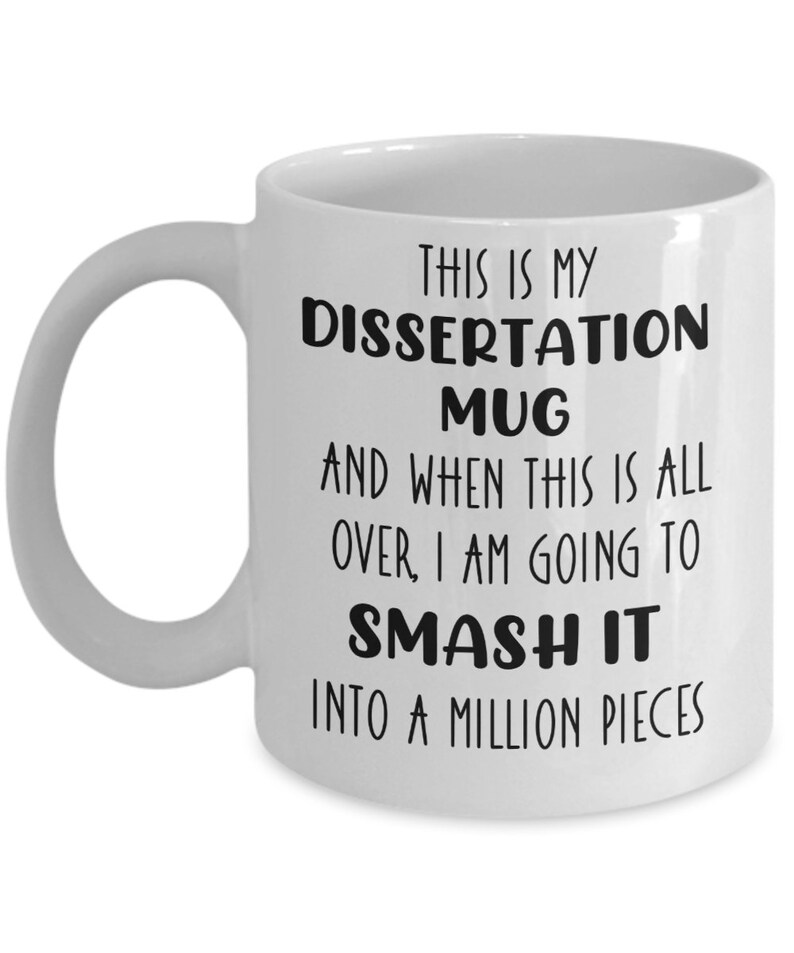 May include: White ceramic mug with a curved handle. The mug features black text that reads: "THIS IS MY DISSERTATION MUG AND WHEN THIS IS ALL OVER, I AM GOING TO SMASH IT INTO A MILLION PIECES."
