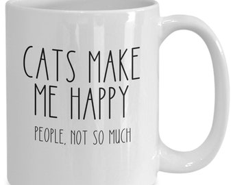 Puede incluir: Taza de cerámica blanca con el texto negro "CATS MAKE ME HAPPY PEOPLE, NOT SO MUCH". La taza tiene un asa curva y está diseñada para bebidas calientes. Un regalo humorístico para los amantes de los gatos.
