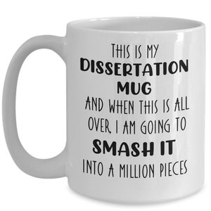 May include: White ceramic mug with a curved handle. The mug features black text that reads: "THIS IS MY DISSERTATION MUG AND WHEN THIS IS ALL OVER, I AM GOING TO SMASH IT INTO A MILLION PIECES."