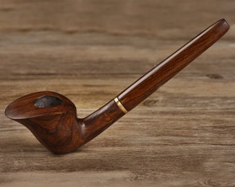 May include: A dark brown wooden smoking pipe with a gold band. The pipe has a curved bowl and a long, straight stem.