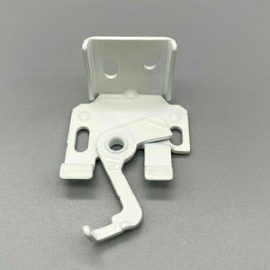 Puede incluir: Soporte de metal blanco con una palanca y un agujero para un tornillo. El soporte está diseñado para montar una persiana de ventana.