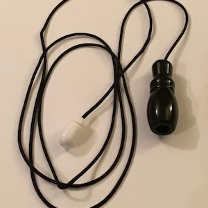 May include: Black and white pull cord for a light fitting. The cord is made of black string and has a white plastic end and a black wooden pull.