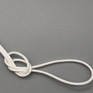May include: A white cord tied in a knot with a loop at the end.