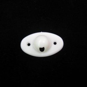 Pode incluir: Luminária oval de plástico branco com um furo redondo no centro e dois pequenos furos nas laterais.