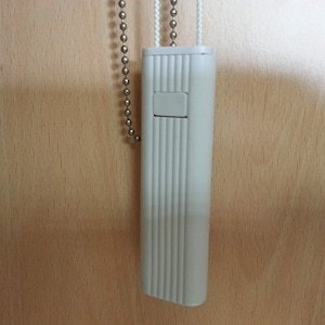 Peut inclure: Cordon de tirage de store blanc en plastique avec une chaîne argentée. Le cordon a une texture nervurée et un petit bouton rectangulaire.