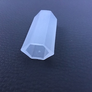 Pode incluir: Um tubo hexagonal de plástico transparente com um centro oco.