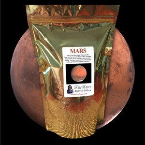 May include: A gold bag of Mars Valls Munda coffee with a label that says "MARS 100% Pure Mars Valls Munda Coffee Now you too can even Mars Coffee more free... thanks to our patented Mars to Earth zip line. This is a very smooth, lower acidity coffee, perfect for breakfast or launch!"  The label also has a picture of the planet Mars and the text "King Hari's Imperial Coffees www.kingharv.com"