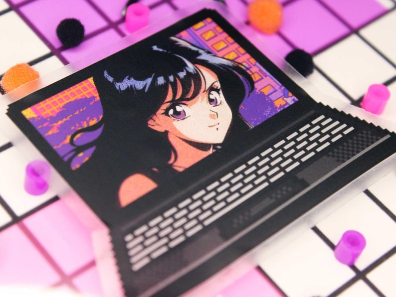 Pixel art retro anime girl sticker on a laptop with a clear backing.