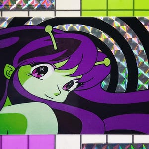 May include: A vibrant illustration of an alien girl with green skin, purple hair, and large eyes. The artwork features a black background with silver, holographic stripes. The alien has antennae and a smiling expression.